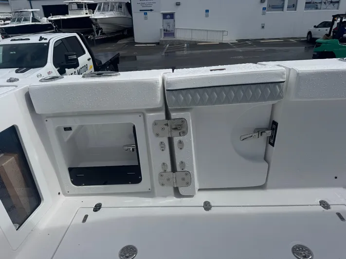  Yacht Photos Pics 2026 Blackfin 302 CC boat deck with storage compartments and wet surface.