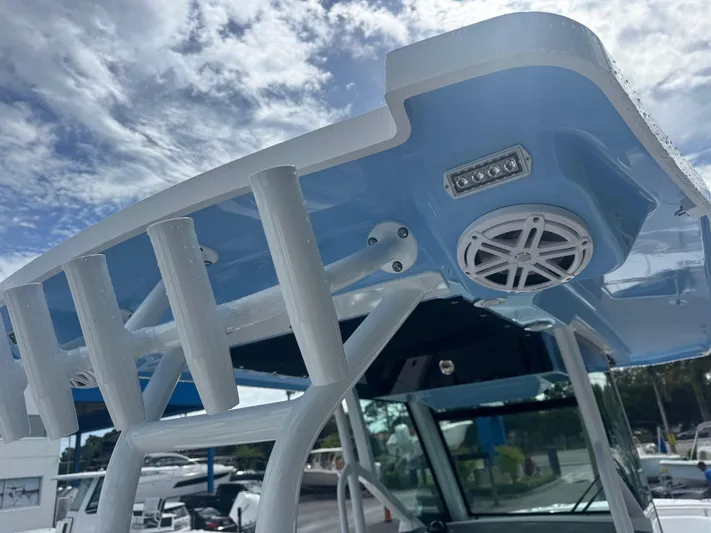  Yacht Photos Pics 2026 Blackfin 302 CC boat T-top with speakers and rod holders under a cloudy sky.