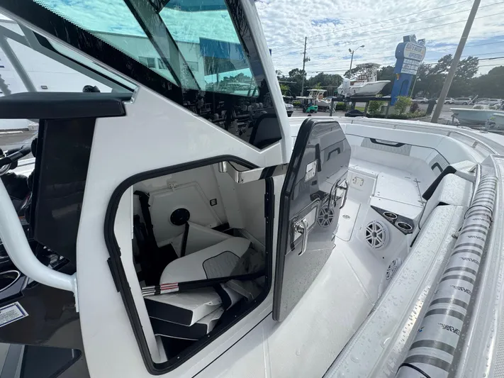  Yacht Photos Pics 2026 Blackfin 302 CC boat interior with open cabin door, showcasing seating and speakers.