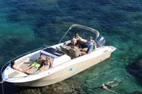 2023 Pacific Craft 750 Open boat with people relaxing on clear blue water.