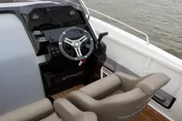 2023 Pacific Craft 750 Open boat cockpit with steering wheel and comfortable seating.