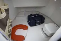 Interior of 2023 Pacific Craft 750 Open boat with storage and portable toilet.