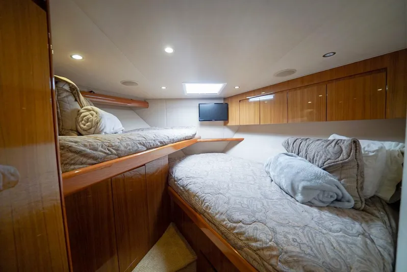 Synchronicity Yacht Photos Pics Cozy cabin interior of 2013 Viking 55 Convertible yacht with twin beds and wooden cabinetry.
