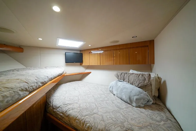 Synchronicity Yacht Photos Pics Cozy cabin interior of 2013 Viking 55 Convertible yacht with twin beds and wooden cabinets.