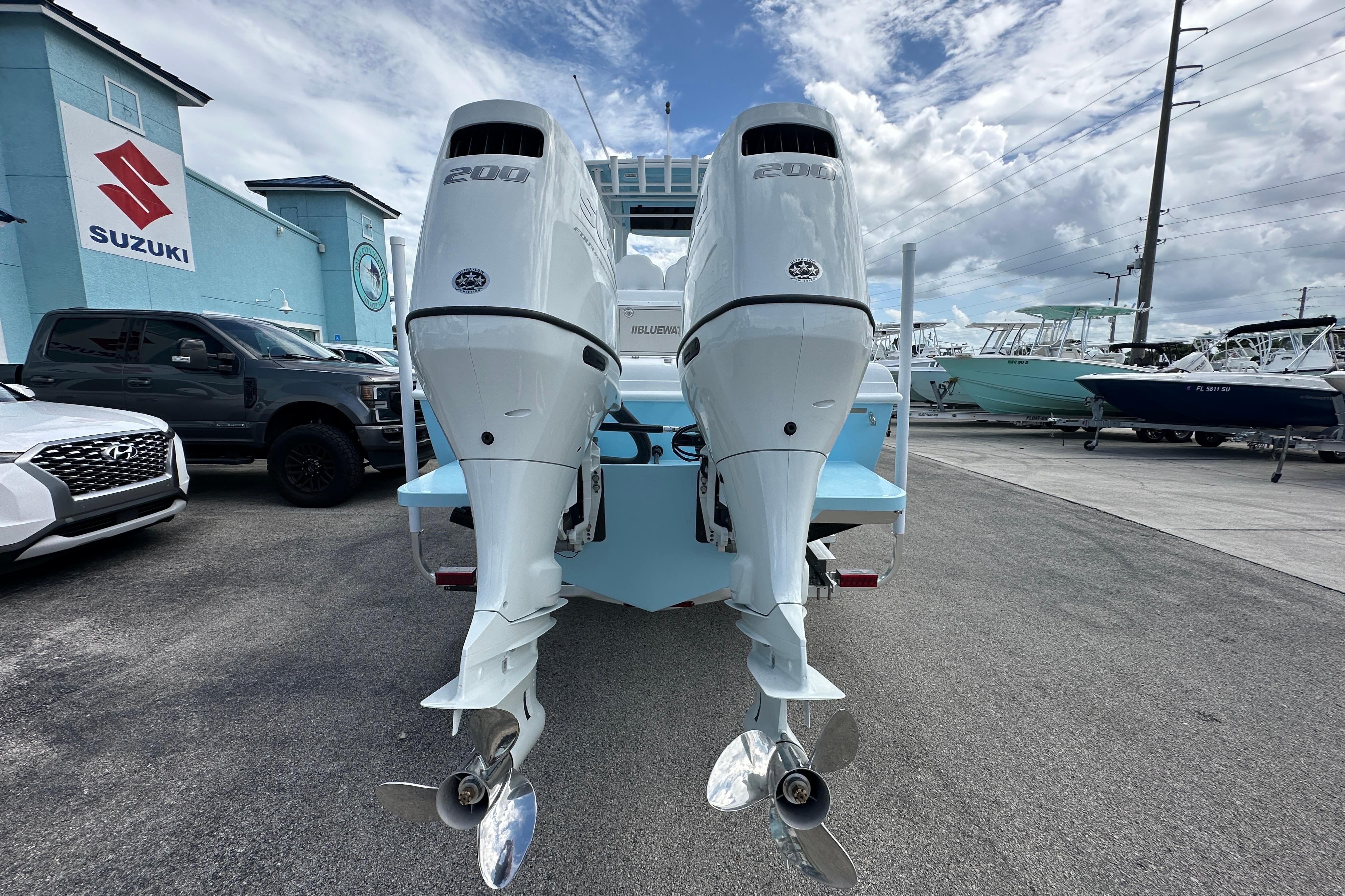 2026 Bluewater 25t boat with dual 200 horsepower engines at a dealership.