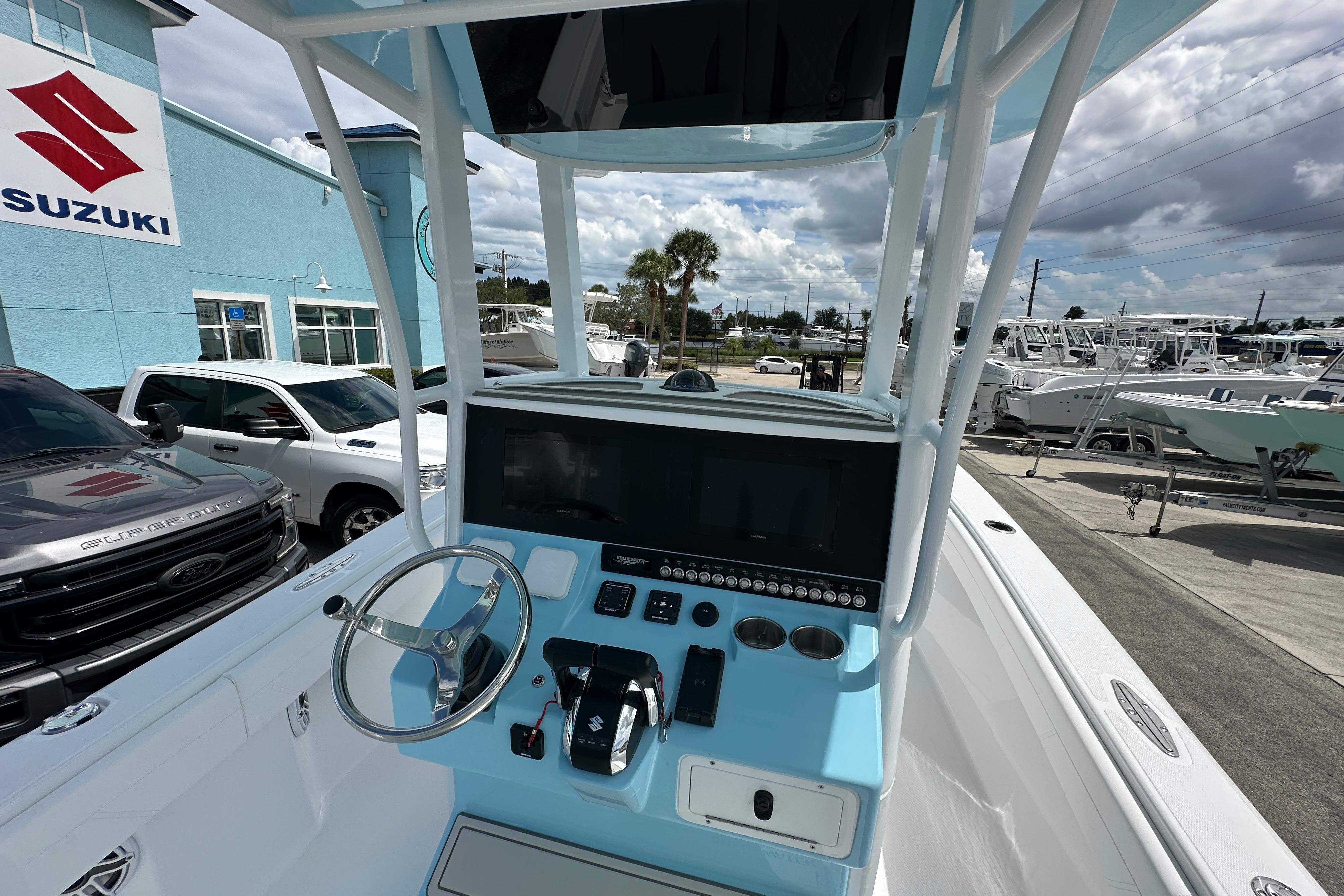 2026 Bluewater 25t boat dashboard with steering wheel, controls, and display at a Suzuki dealership.