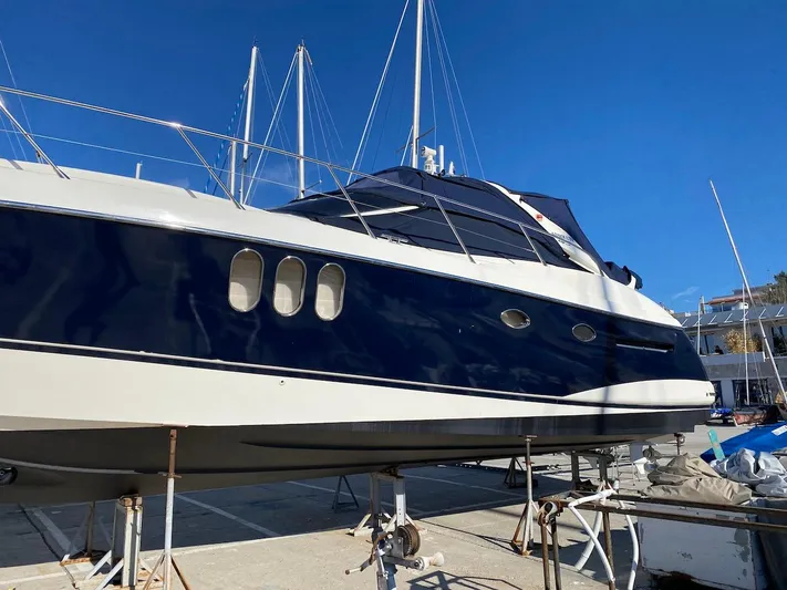  Yacht Photos Pics Luxury Absolute 45 yacht from 2006 on dry dock under clear blue sky.