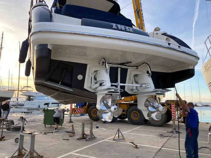  Yacht Photos Pics Luxury yacht Absolute 45, 2006 model, in dry dock with visible propellers and maintenance crew.