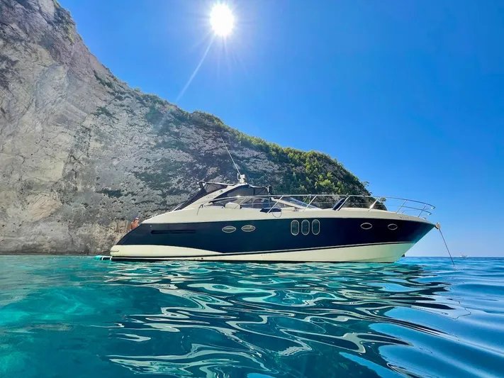  Yacht Photos Pics Luxury Absolute 45 yacht from 2006 on clear blue water near rocky cliff.