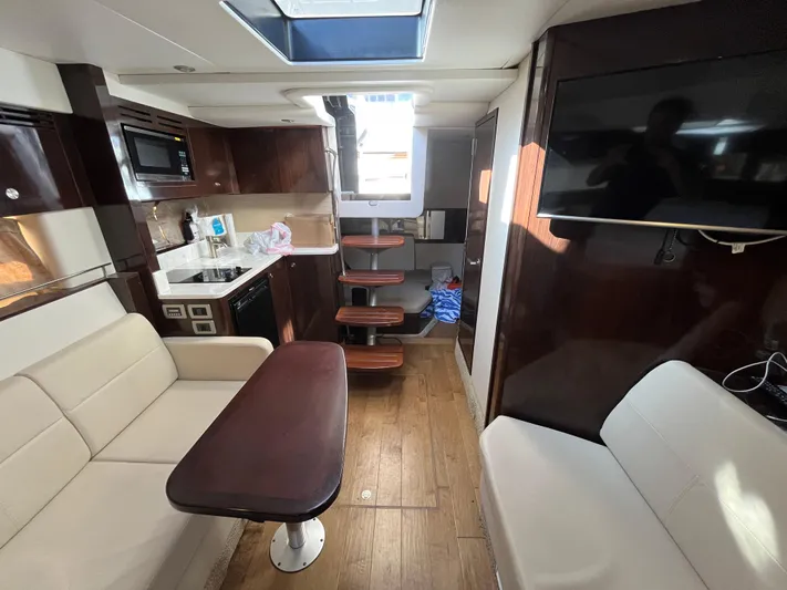  Yacht Photos Pics 2018 Sea Ray Sundancer 350 interior with modern kitchen, seating, and wooden flooring.