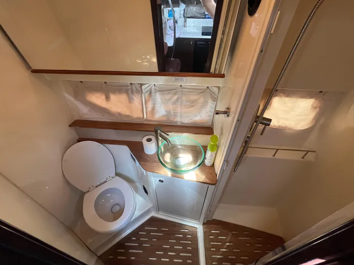  Yacht Photos Pics 2018 Sea Ray Sundancer 350 bathroom with toilet, glass sink, and wooden accents.