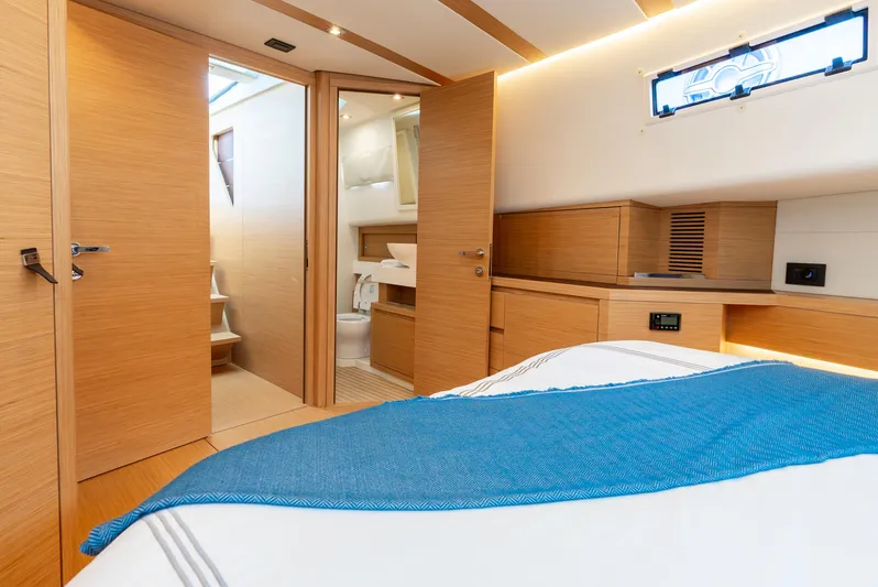 Exit Strategy Yacht Photos Pics Luxurious interior of 2023 Pardo Yachts 50, featuring modern wood finishes and cozy bedding.