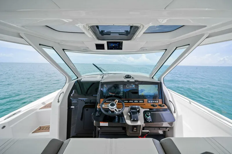  Yacht Photos Pics 2023 Tiara Yachts 38 LS helm with advanced navigation system, overlooking the ocean.