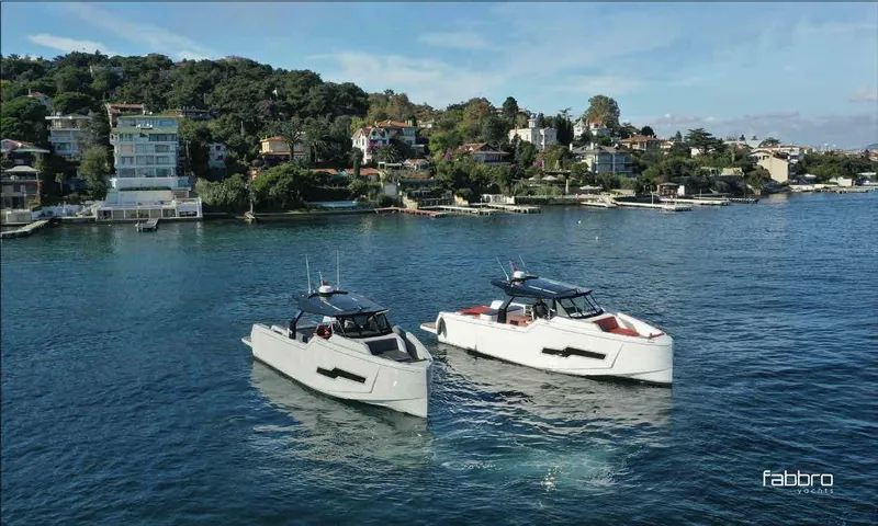 Therapy 1 Yacht Photos Pics Two 2024 Fabbro F45 boats on a scenic waterfront with lush greenery.