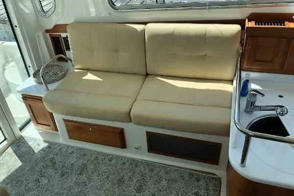  Yacht Photos Pics 2018 Back Cove Downeast 37 interior with beige seating and compact kitchenette.
