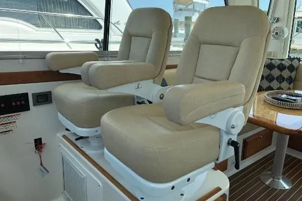  Yacht Photos Pics 2018 Back Cove Downeast 37 interior with beige captain chairs and wooden flooring.