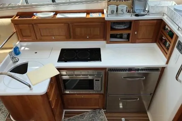  Yacht Photos Pics 2018 Back Cove Downeast 37 yacht kitchen with modern appliances and wooden cabinetry.