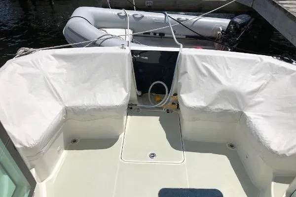  Yacht Photos Pics 2018 Back Cove Downeast 37 boat deck with white seating and docked inflatable dinghy.