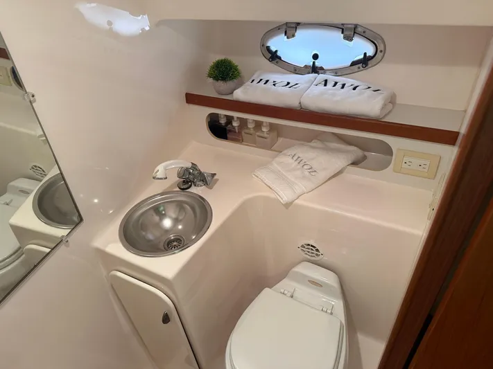 Awol Yacht Photos Pics Compact bathroom in 2003 Tiara Yachts 3100 Open LE, featuring sink, toilet, and porthole window.