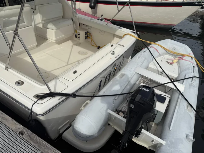 Awol Yacht Photos Pics 2003 Tiara Yachts 3100 Open LE docked with inflatable boat, featuring spacious deck area.