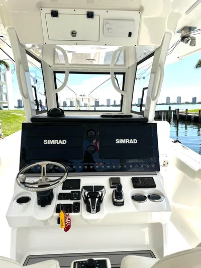  Yacht Photos Pics 2022 Sea Pro 320 DLX Center Console with dual Simrad displays, docked by waterfront.