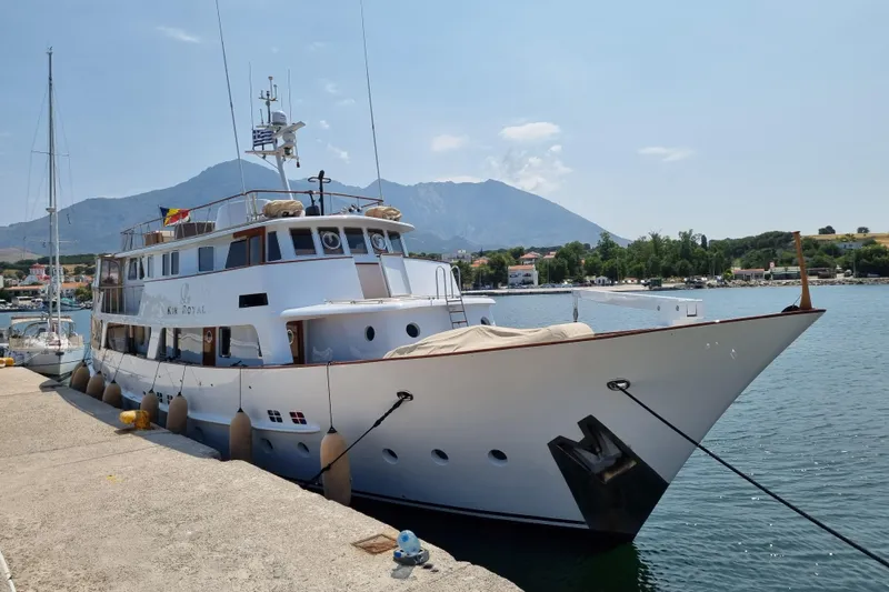 Le Kir Royal Yacht Photos Pics 1966 Van den Akker Displacement yacht docked in scenic harbor with mountains in background.