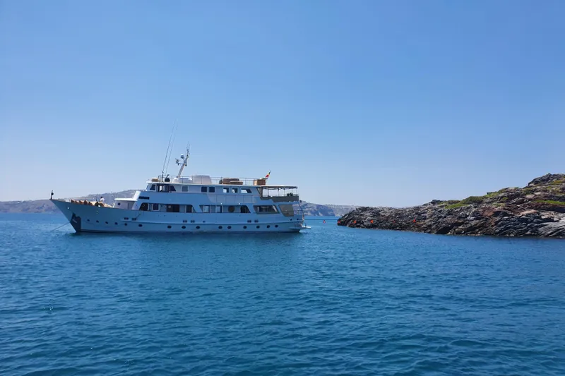 Le Kir Royal Yacht Photos Pics 1966 Van den Akker Displacement yacht cruising near rocky coastline under clear blue sky.