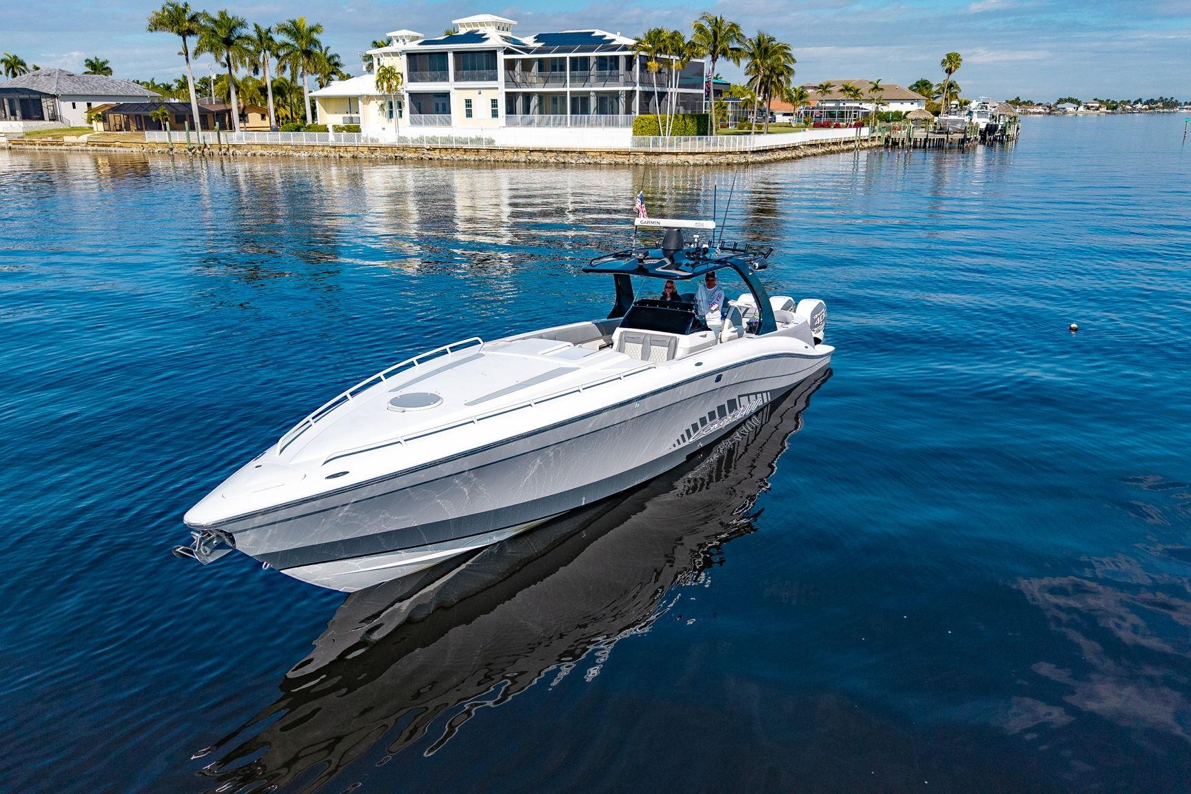 2010 Concept 4400 Sport Yacht cruising on calm waters near luxury waterfront homes.