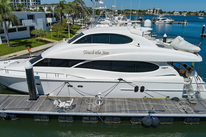 Touch The Sun Yacht Photos Pics Luxury 2004 Lazzara 80 SL yacht docked at marina, surrounded by water and palm trees.