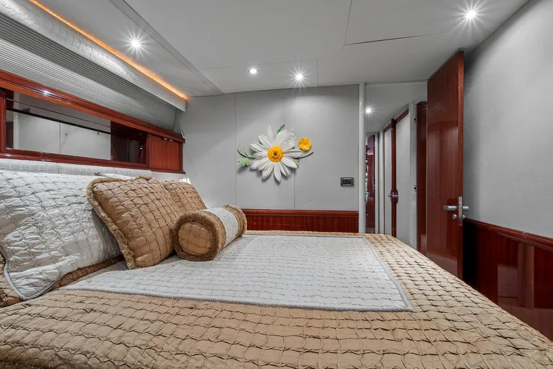Touch The Sun Yacht Photos Pics Luxurious bedroom interior on 2004 Lazzara 80 SL yacht with elegant bedding and floral decor.