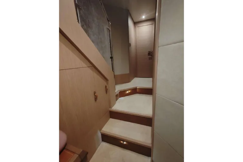  Yacht Photos Pics Interior staircase of 2015 Beneteau Monte Carlo 6 yacht, featuring elegant wood finish.