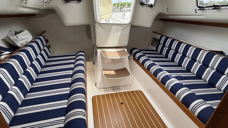 Seabird Yacht Photos Pics Interior of 2012 J Boats J/95 sailboat with striped seating and wooden flooring.