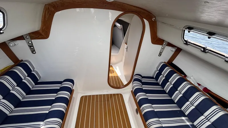 Seabird Yacht Photos Pics Interior of 2012 J Boats J/95 sailboat with striped seating and wooden accents.