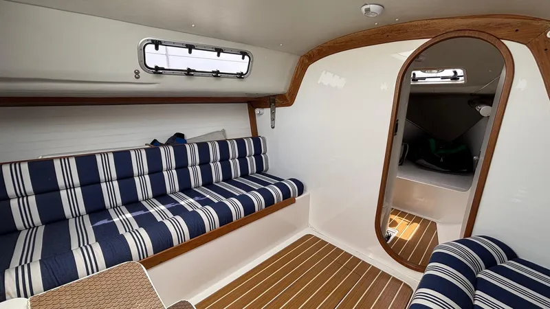 Seabird Yacht Photos Pics Interior of 2012 J Boats J/95 sailboat with striped seating and wood accents.