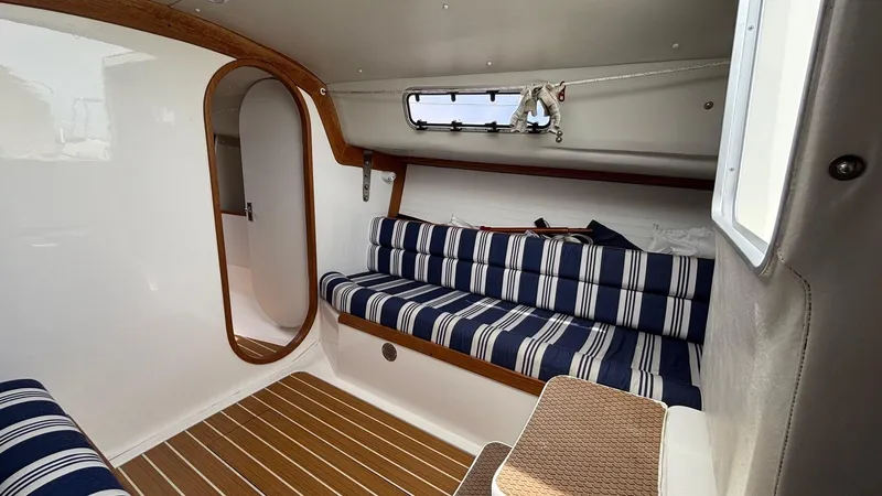 Seabird Yacht Photos Pics Interior of 2012 J Boats J/95 sailboat with striped seating and wooden accents.