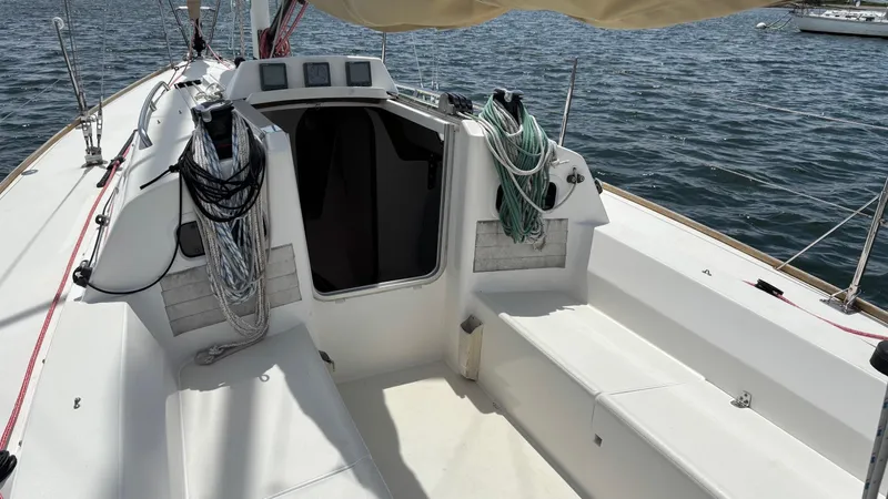 Seabird Yacht Photos Pics 2012 J Boats J/95 sailboat cockpit with ropes and seating, on calm water.