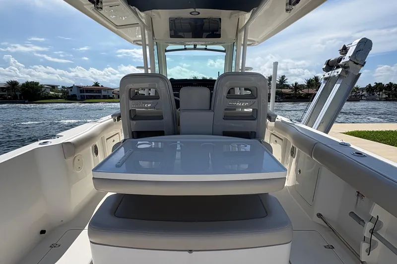  Yacht Photos Pics 2017 Boston Whaler 330 Outrage interior with seating and table, overlooking waterfront homes.