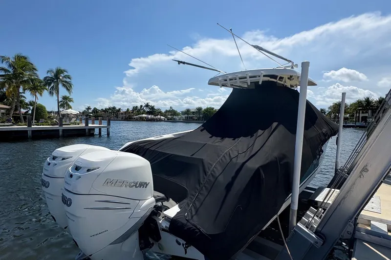  Yacht Photos Pics 2017 Boston Whaler 330 Outrage with Mercury engines, docked and covered, under a sunny sky.