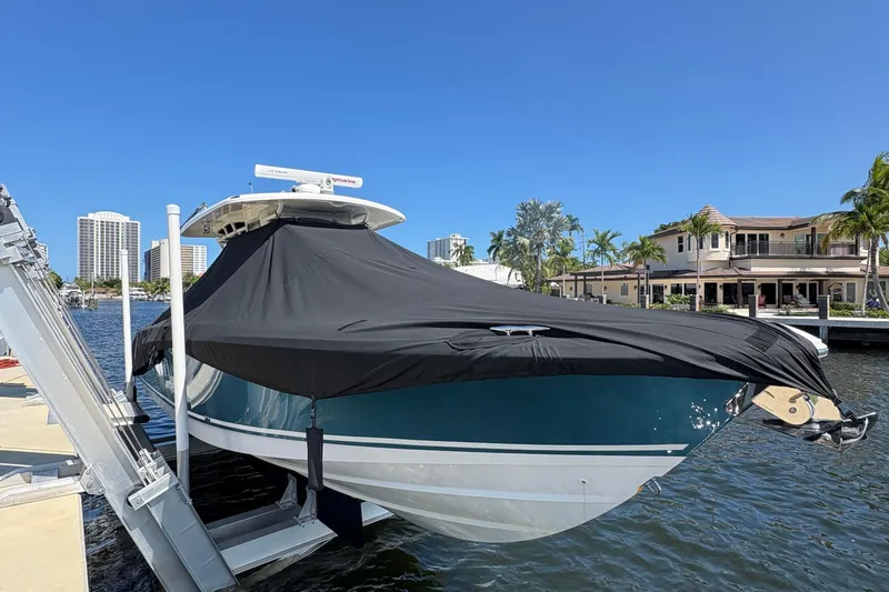  Yacht Photos Pics 2017 Boston Whaler 330 Outrage boat covered, docked near waterfront homes.