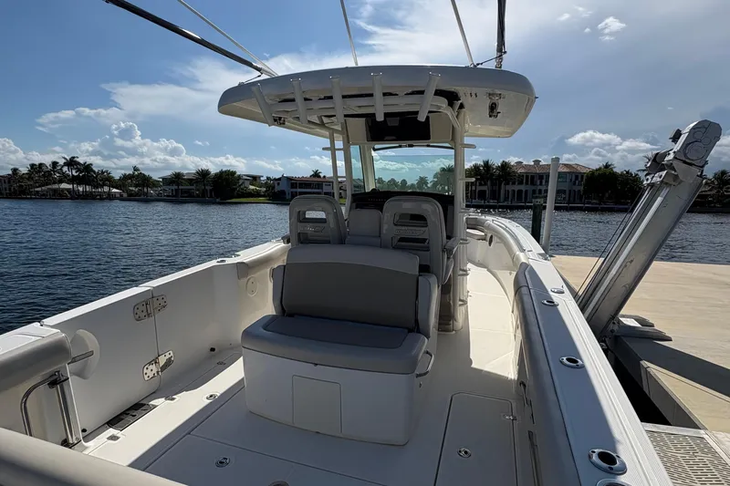  Yacht Photos Pics 2017 Boston Whaler 330 Outrage boat docked by waterfront homes under a sunny sky.
