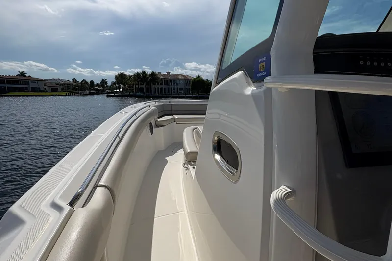  Yacht Photos Pics 2017 Boston Whaler 330 Outrage boat on calm water, showcasing sleek design and spacious deck.