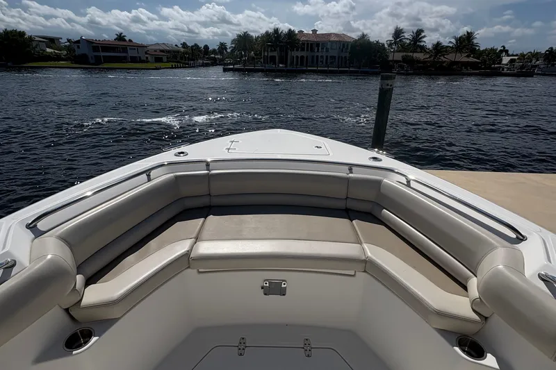  Yacht Photos Pics 2017 Boston Whaler 330 Outrage boat with spacious seating, docked by waterfront homes.