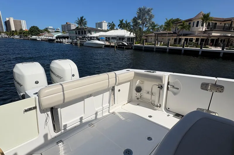  Yacht Photos Pics 2017 Boston Whaler 330 Outrage boat docked by waterfront homes, featuring dual Mercury engines.