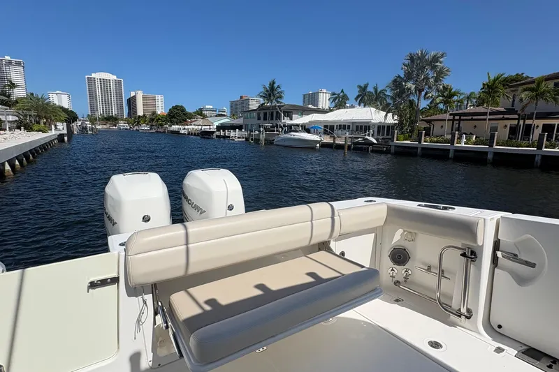  Yacht Photos Pics 2017 Boston Whaler 330 Outrage boat on a sunny waterfront with city skyline.
