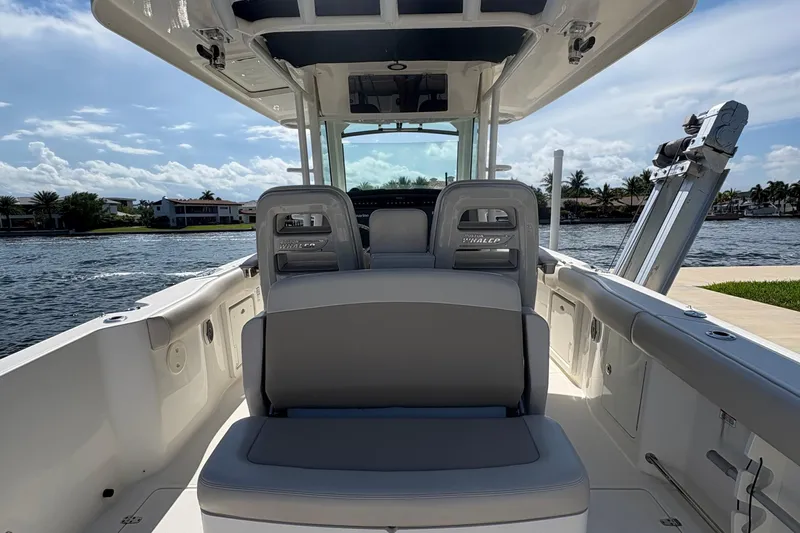  Yacht Photos Pics 2017 Boston Whaler 330 Outrage boat interior with seating, on a sunny waterfront.