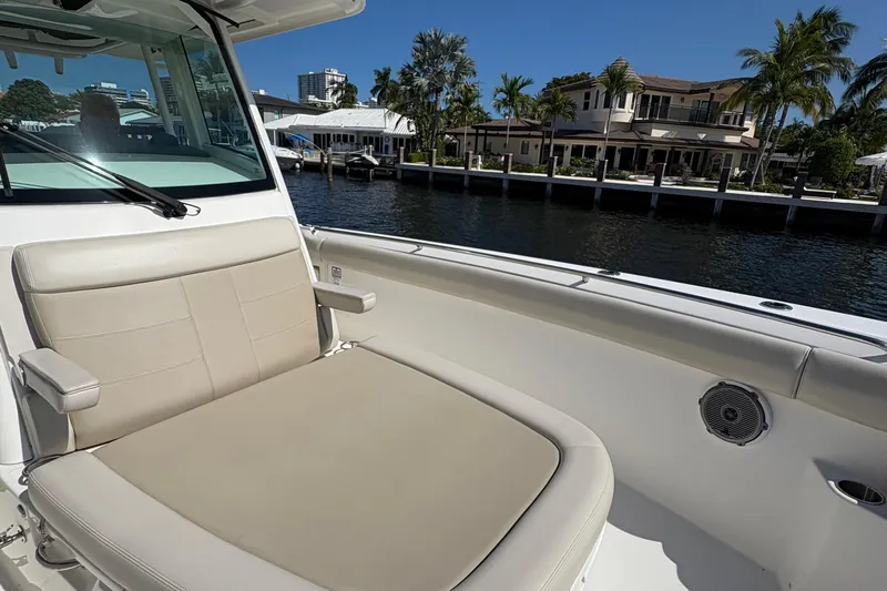  Yacht Photos Pics 2017 Boston Whaler 330 Outrage boat interior with beige seating, dockside view.