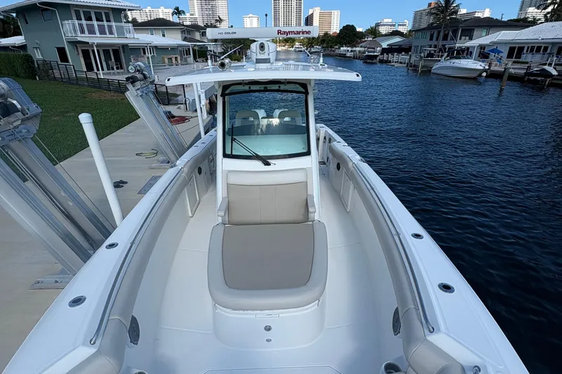  Yacht Photos Pics 2017 Boston Whaler 330 Outrage boat docked in a marina, featuring spacious seating.