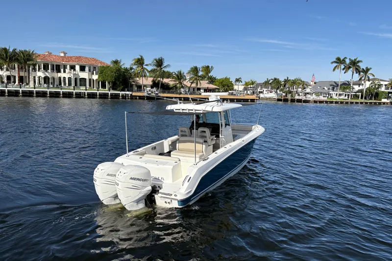  Yacht Photos Pics 2017 Boston Whaler 330 Outrage boat on water, luxury waterfront homes in background.
