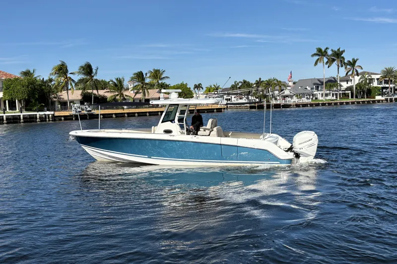  Yacht Photos Pics 2017 Boston Whaler 330 Outrage boat cruising on a sunny day near waterfront homes.