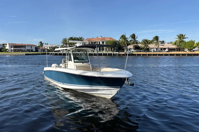  Yacht Photos Pics 2017 Boston Whaler 330 Outrage boat on calm water near waterfront homes.